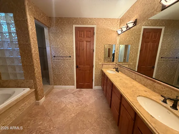 a bathroom with a granite countertop sink a mirror and a bathtub