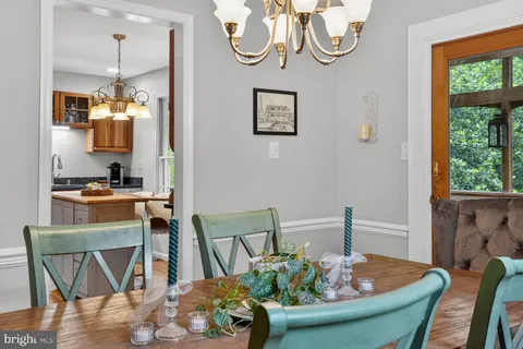 a dining room filled chandelier and wooden floor
