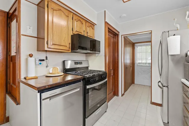 a kitchen with stainless steel appliances granite countertop a stove top oven a sink and a refrigerator