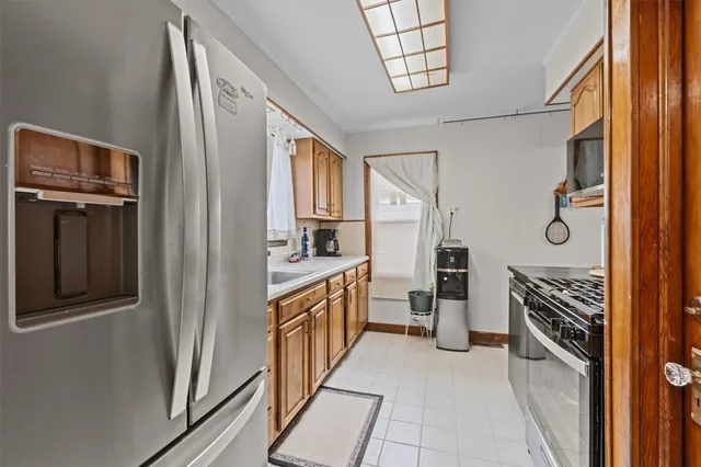 a kitchen with granite countertop a refrigerator and a stove top oven