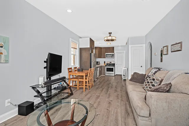 a living room with furniture a flat screen tv and a table