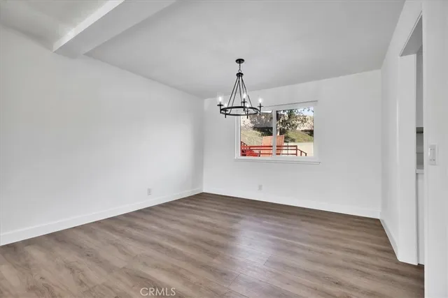 a view of a room with wooden floor chandelier and entryway