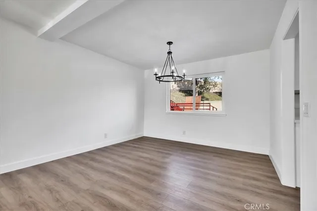 a view of a room with wooden floor chandelier and entryway