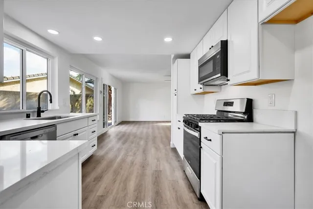 a kitchen with stainless steel appliances granite countertop a stove a sink and a microwave
