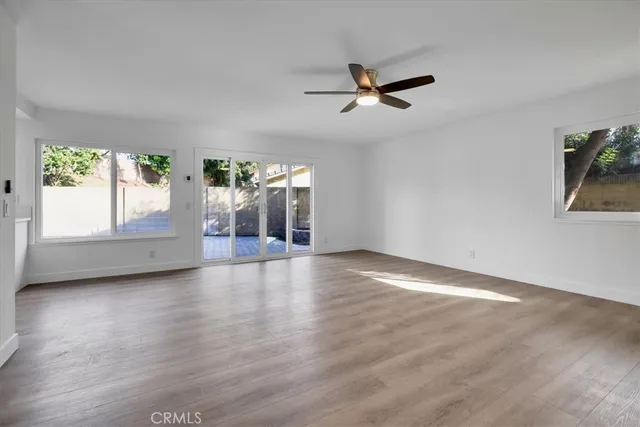 a view of a livingroom with wooden floor and a window