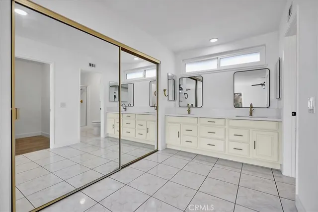 a bathroom with a sink a toilet and large mirror