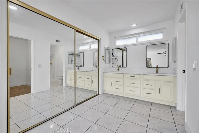 a bathroom with a sink a toilet and large mirror