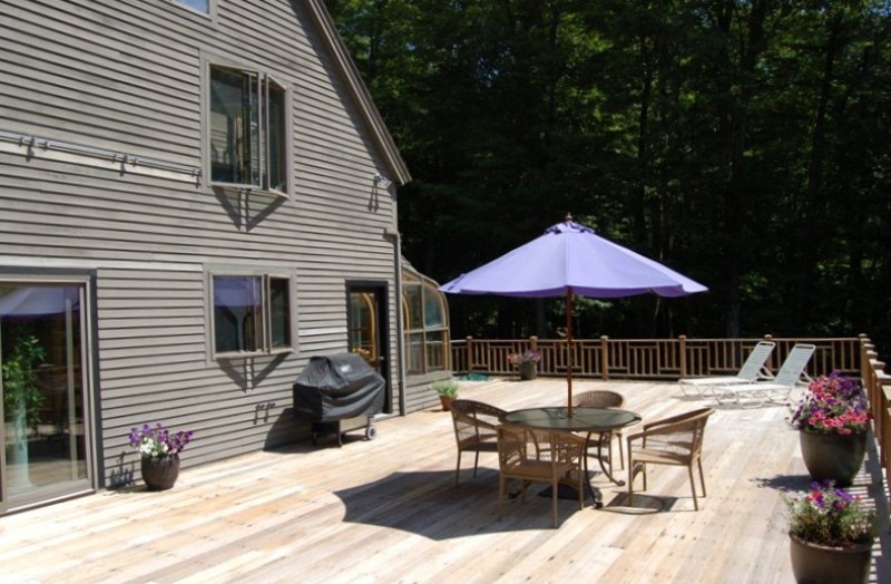 147 Reservoir Road Lenox, MA 01240 - Photo 23 of 31 a view of a patio with a table and chairs under an umbrella
