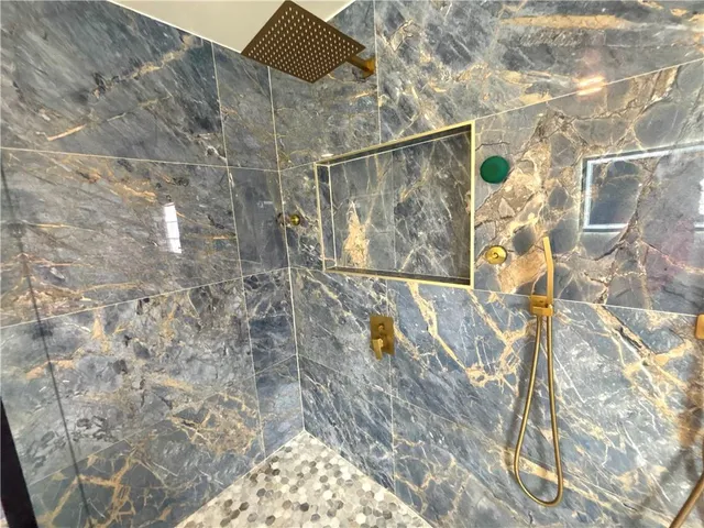 a bathroom with a sink a toilet a mirror and shower