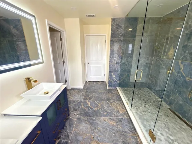a bathroom with a sink a mirror and a shower
