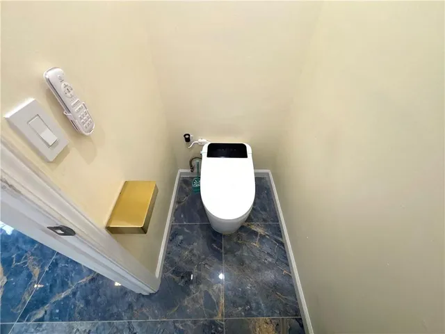 a bathroom with a granite countertop sink a toilet and a mirror
