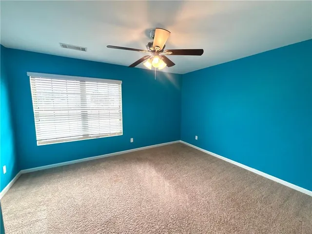 an empty room with window and chandelier fan