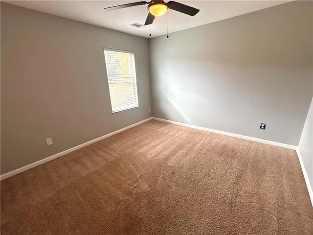 a view of a backyard with a bench and iron fence