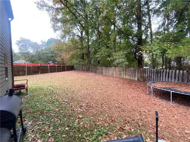 a view of a house with backyard and trees