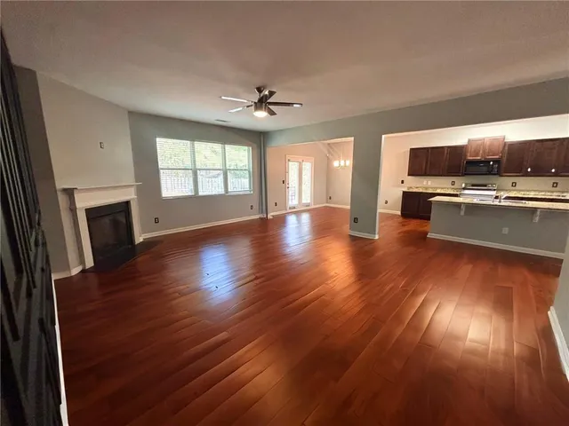 a view of kitchen with microwave a stove and wooden floor