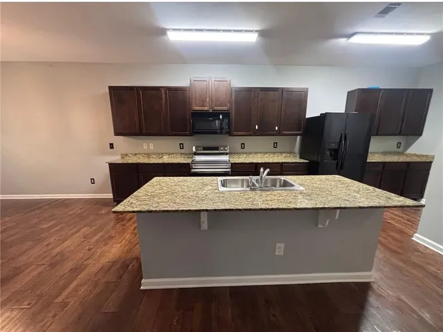 a kitchen with kitchen island a sink refrigerator and a stove