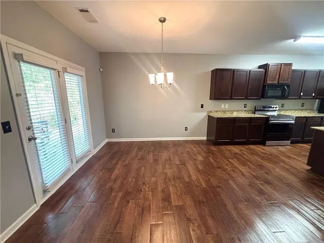 a kitchen with kitchen island granite countertop a stove a sink and a refrigerator