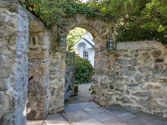 a view of a house with a big yard and large trees