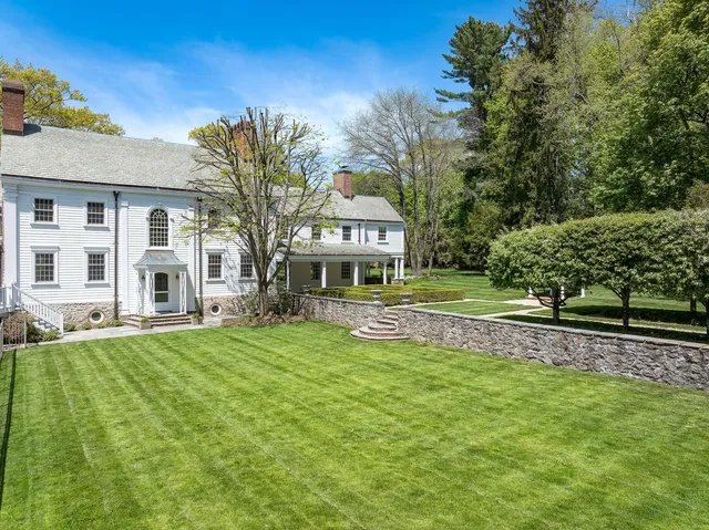 a front view of a house with white fence