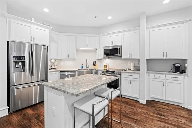 a kitchen with granite countertop a refrigerator stove and sink