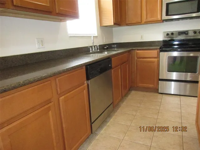 a kitchen with stainless steel appliances granite countertop a sink stove and cabinets