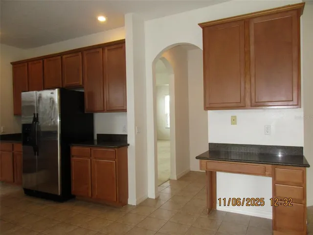 a kitchen with granite countertop stainless steel appliances a refrigerator and cabinets