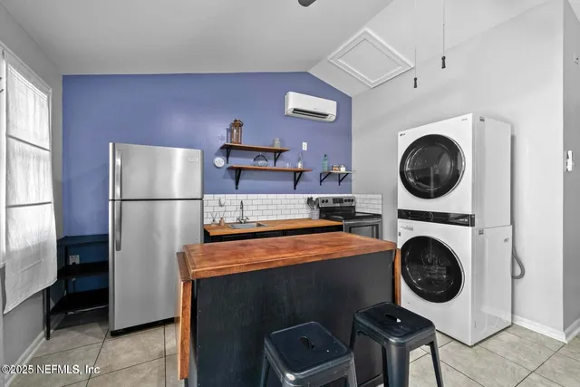 a kitchen with a refrigerator and a washer dryer