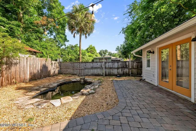 a view of a backyard with a large tree and wooden fence