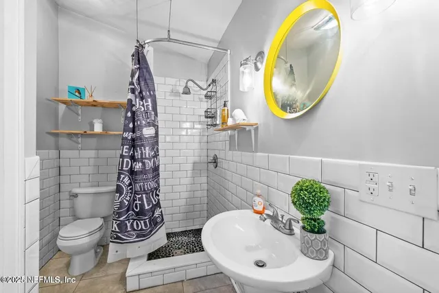 a bathroom with a toilet sink and mirror