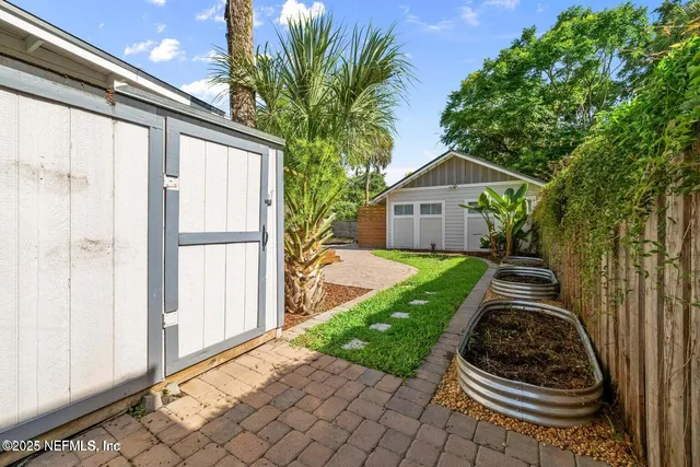 a front view of a house with a yard and potted plants