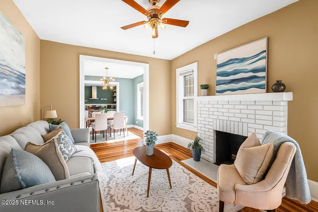 a living room with furniture a fireplace and a large window