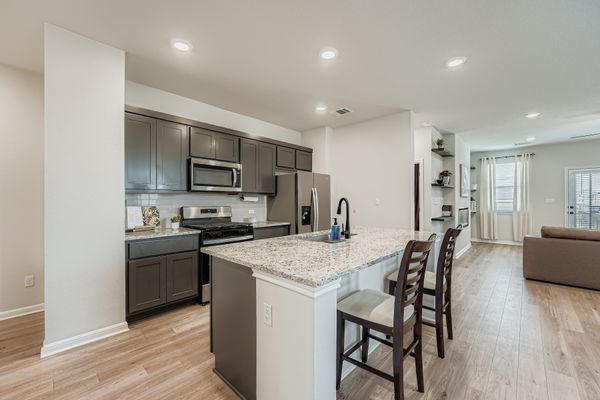 148 Gullivers Drive Elgin, TX 78621 - Photo 20 of 21 Kitchen featuring a breakfast bar, stainless steel appliances, a kitchen island with sink, light wood-type flooring, and open floor plan