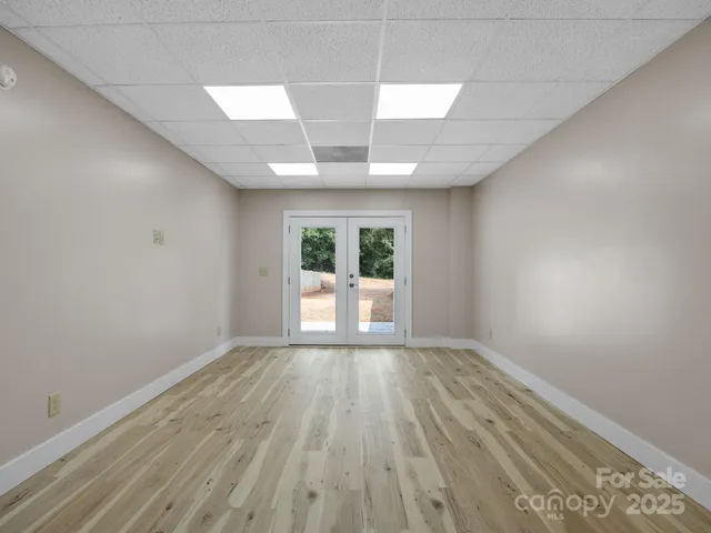 an empty room with wooden floor and entryway