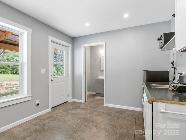 a kitchen with a sink and chairs