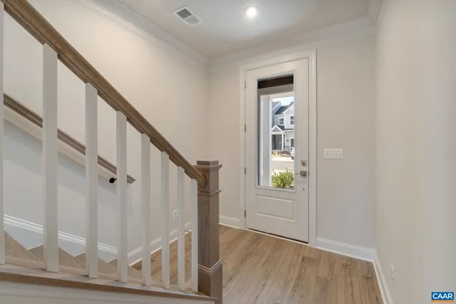 a view of an entryway with wooden floor and door