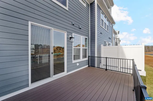 a view of a balcony with wooden floor and fence and a window