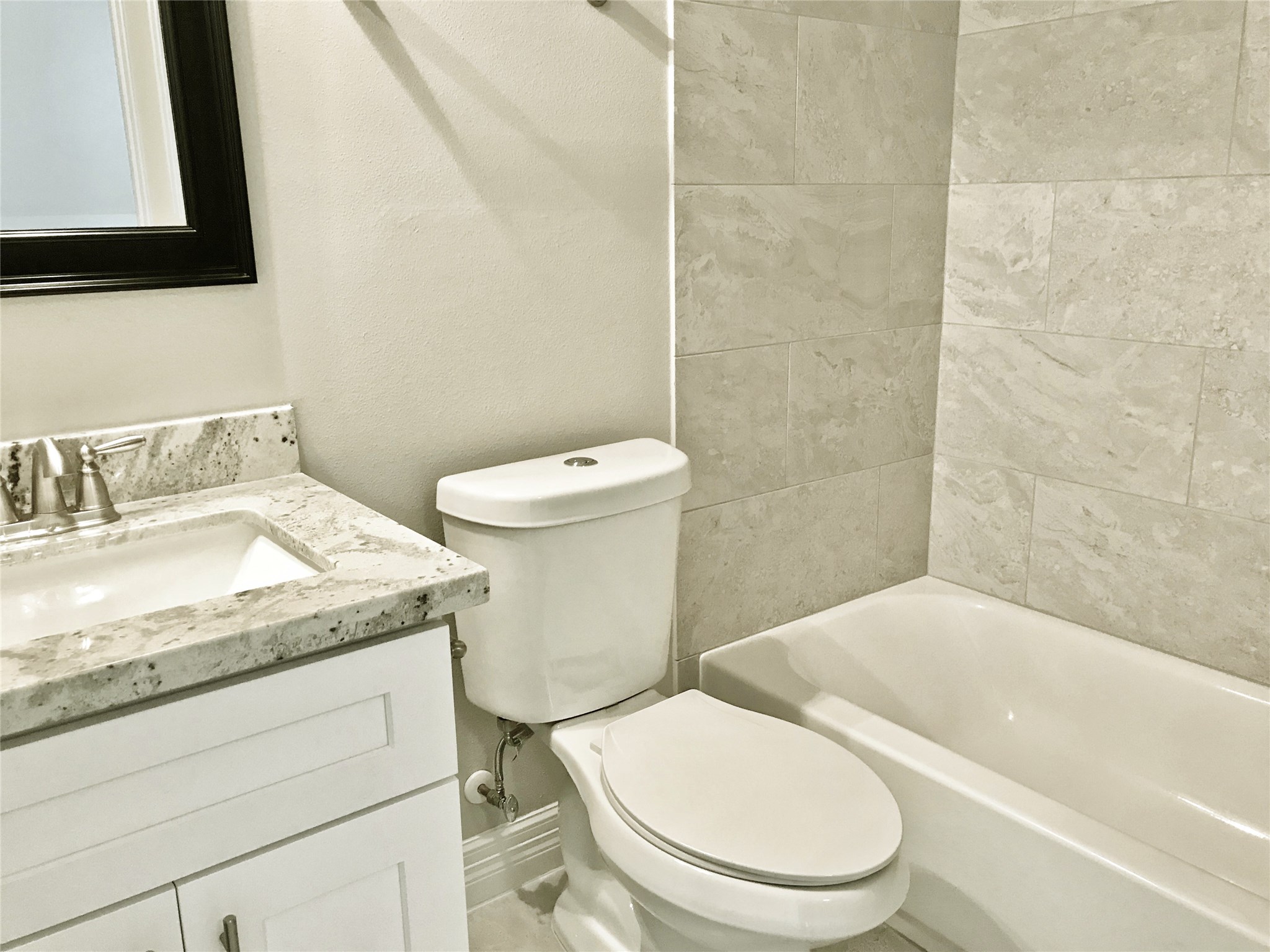 709 Link Road Houston, TX 77009 - Photo 29 of 46 a white toilet sitting next to a bathroom sink and a granite counter top