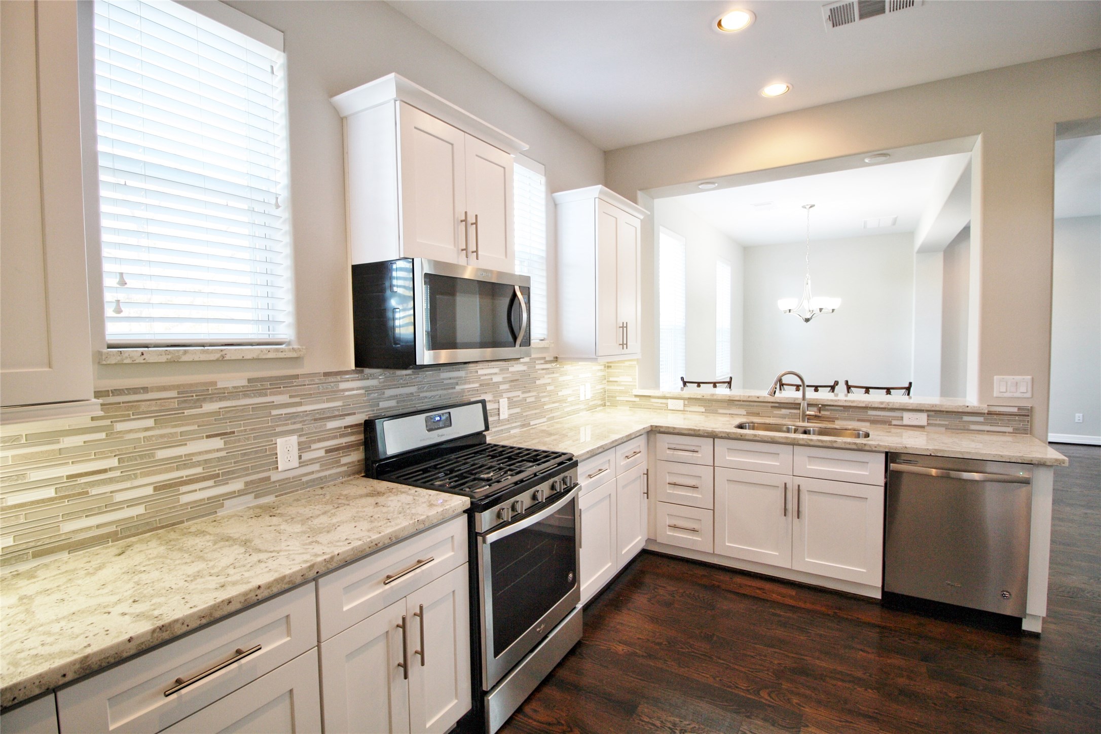 709 Link Road Houston, TX 77009 - Photo 3 of 41 COMPLIMENTARY BACKSPLASH AND GRANITE FOR THE LOVELY GRAY INTERIOR COLORS AND WHITE CABINETS. NOTICE THE WIDE GRANITE BREAKFAST BAR AND THE OPEN CONCEPT WITH VIEWS TO THE DINING/FLEX AND LIVING