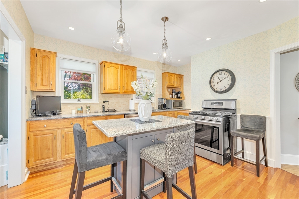 112 Perham Street Boston, MA 02132 - Photo 13 of 36 a kitchen with stainless steel appliances granite countertop a stove a sink dishwasher a dining table and chairs with wooden floor
