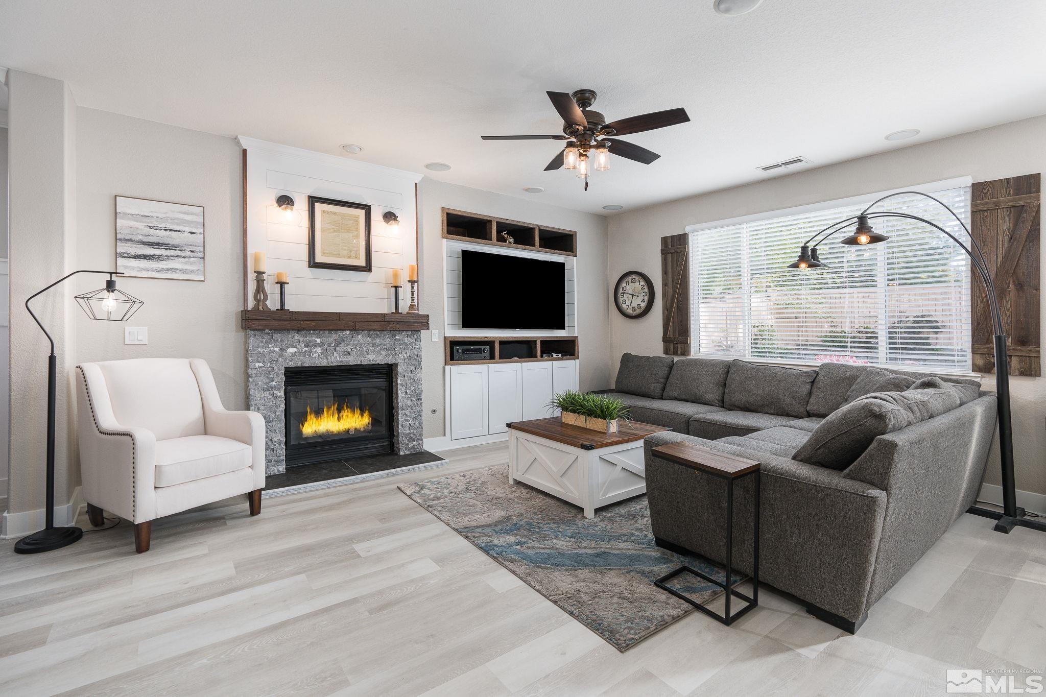 10650 Copper Lake Drive Reno, NV 89521 - Photo 10 of 40 a living room with furniture a flat screen tv and a fireplace
