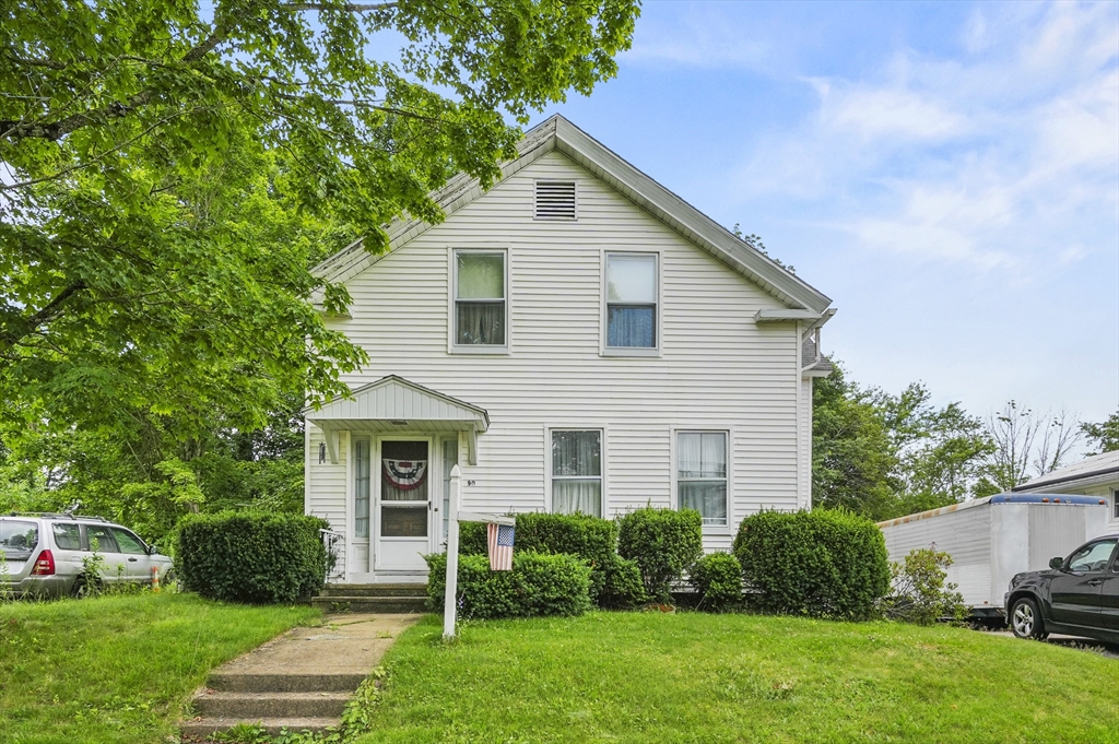 a front view of a house with a yard and trees