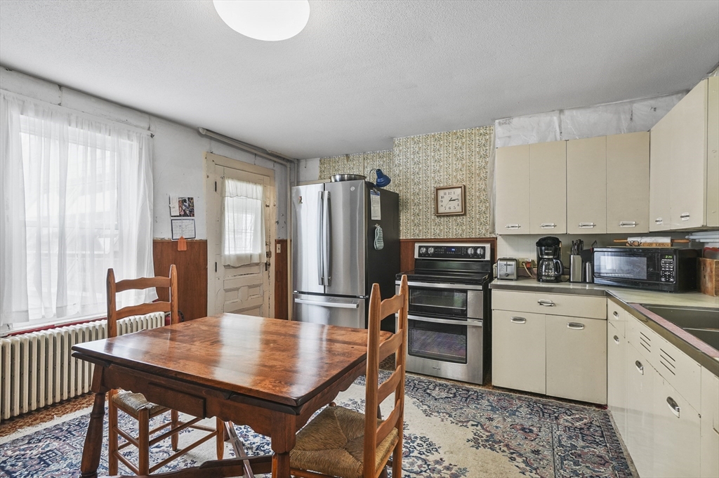 90 Common Street Barre, MA 01005 - Photo 15 of 27 a kitchen with stainless steel appliances granite countertop a stove a sink dishwasher a dining table and chairs with wooden floor