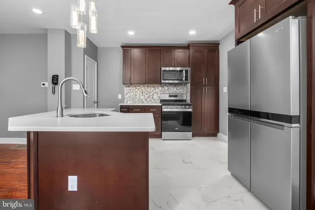 a kitchen with kitchen island a counter top space stainless steel appliances and cabinets