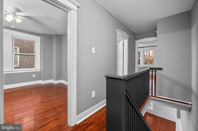 a view of a hallway with wooden floor and stairs