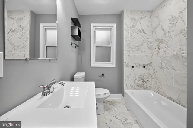 a bathroom with a sink a toilet and bathtub