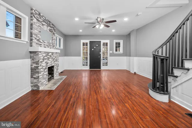 a view of a livingroom with wooden floor and a ceiling fan