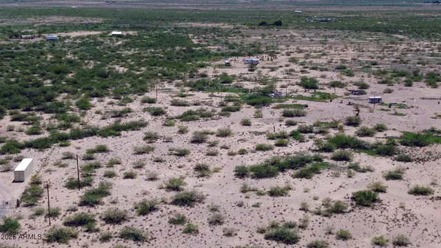a view of a dry yard with wooden fence