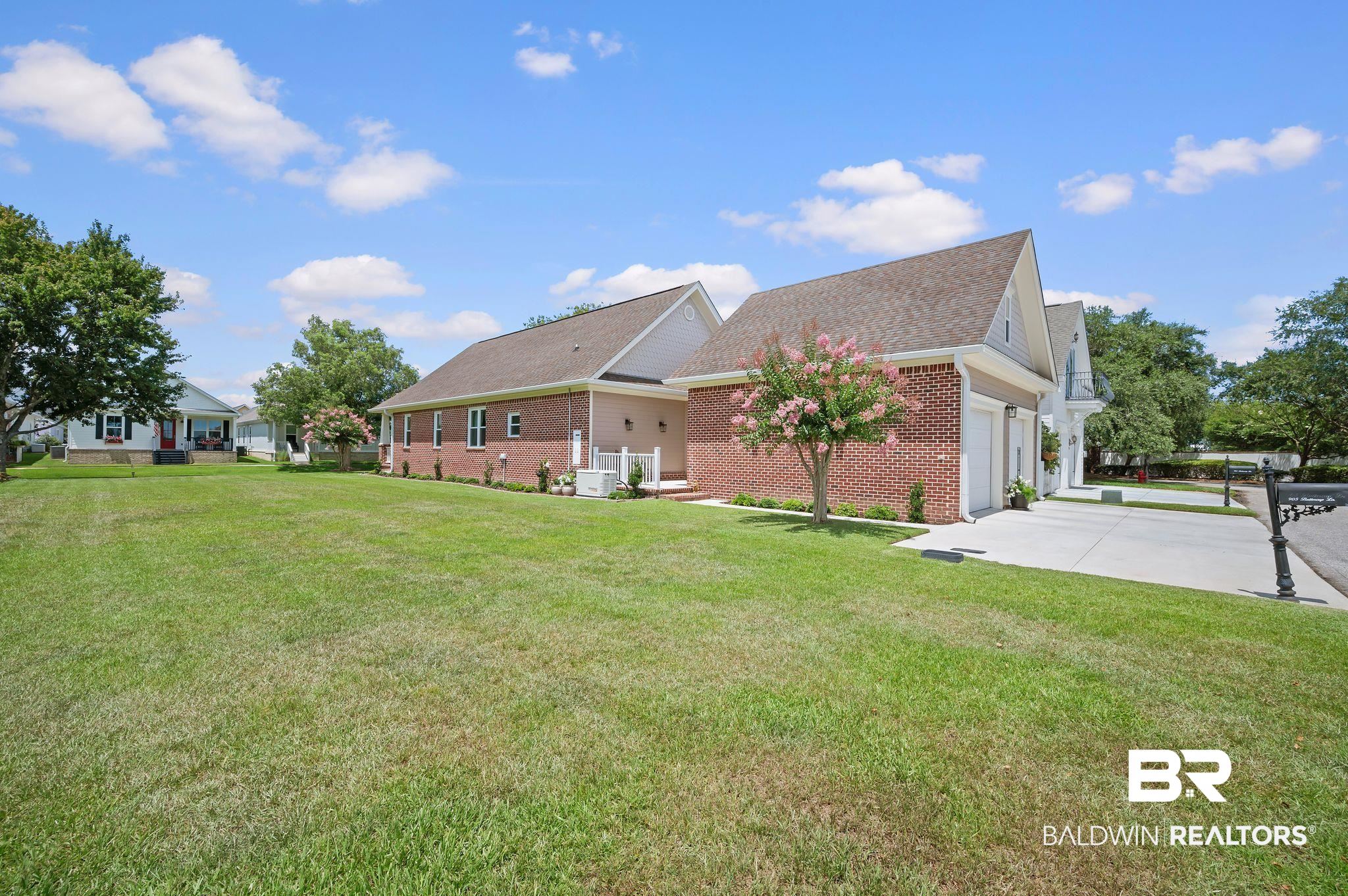 905 Buttercup Lane Foley, AL 36535 - Photo 13 of 47 Rear view of house featuring brick siding, driveway, a garage, a yard, and roof with shingles