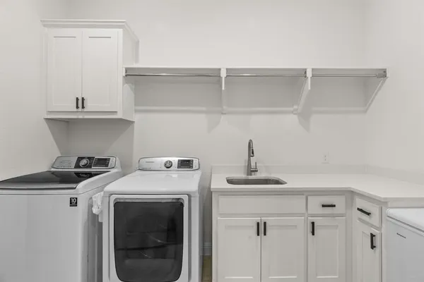 a utility room with sink dryer and washer