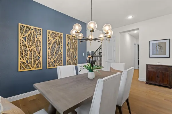 a view of a dining room with furniture a chandelier and wooden floor